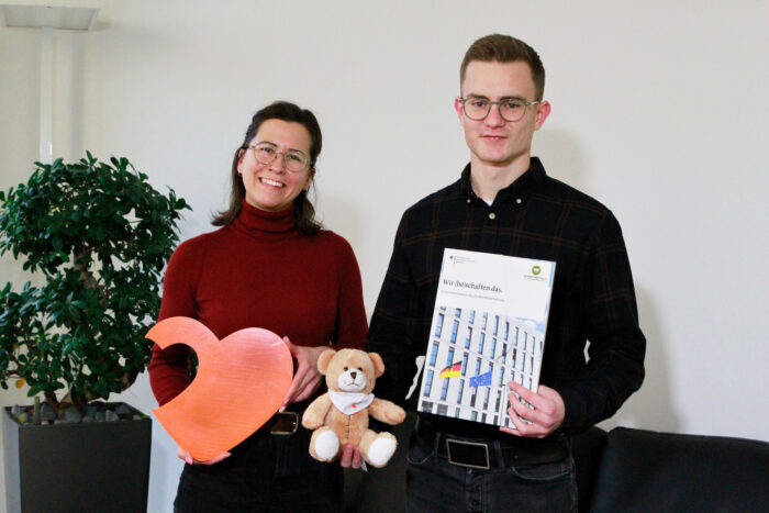 Ein Kollege aus Bonn überreicht den Erlös der Spendenaktion an eine Dame der Stiftung Kinderherzen